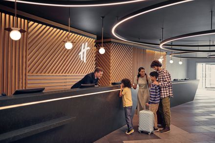 Familie mit Kindern an Hotelrezeption