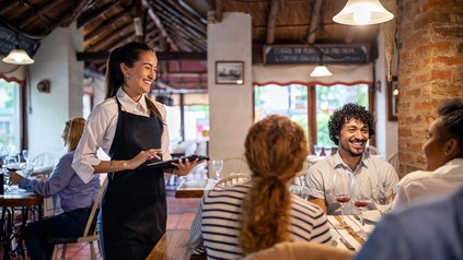 Gäste im Restaurant mit Servicekraft