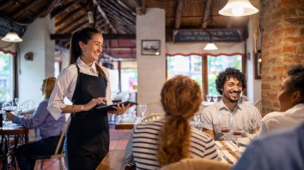 Gäste im Restaurant mit Servicekraft