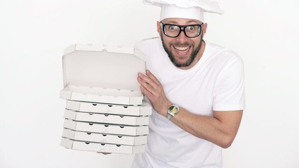 Pizzabäcker mit einem Stapel Pizzaschachteln in der Hand