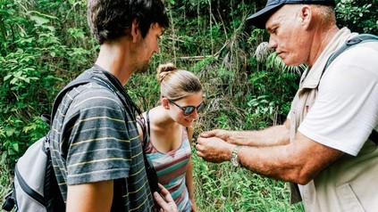 Zwei Touristen mit einem Führer im Wald