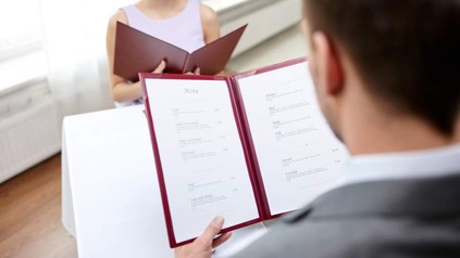 Frau und Mann in Restaurant sehen sich Menü an