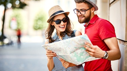 Ein Mann und eine Frau, die lachend eine Karte studieren