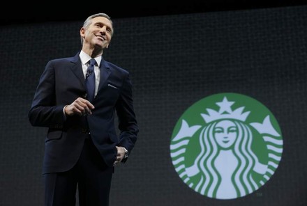 Verwaltungsratschef Schultz vor dem Starbucks Logo
