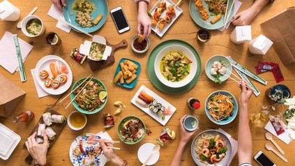 Freundesrunde beim Essen asiatischer Gerichte