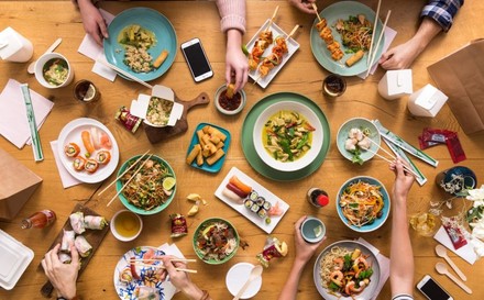 Freundesrunde beim Essen asiatischer Gerichte