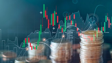 Geldmünzenstapel mit überblendeter Grafik von Aktienkurven