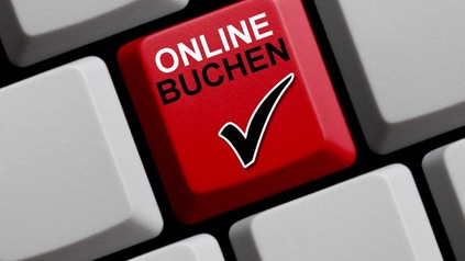 Eine Tastatur mit einem roten Button auf dem Online Buchen steht