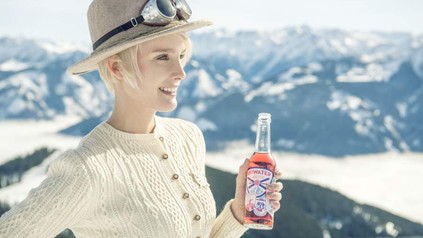 Lachende Frau mit Getränk in der Hand