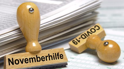 Stempel mit der Aufschrift Covid-19 und Novemberhilfe