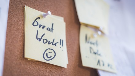 Employee motivation and leadership concept. “Great work” note on pinned paper, cork board