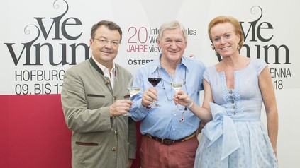 Mag. Willi Klinger, Hugh Johnson und Mag. Alexandra Graski-Hoffmann stoßen gemeinsam vor dem Banner der VieVinum an