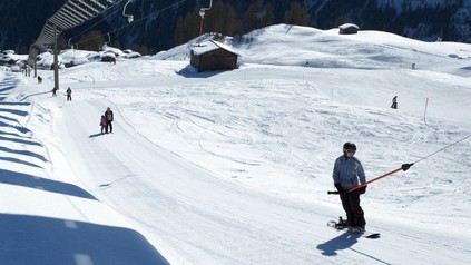 Skifahrer verwenden einen Schlepplift um auf die Piste zu kommen