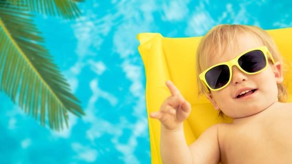 Ein Kind mit Sonnenbrille auf einer Luftmatratze im Pool