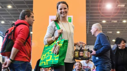 Frau mit grüner Tasche auf Messe