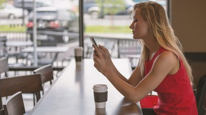 Frau mit Smartphone in Restaurant