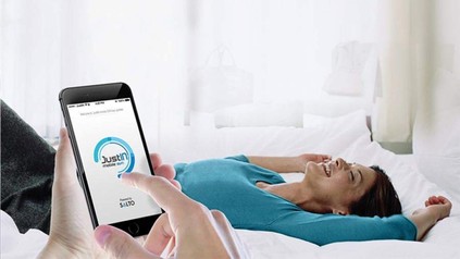 Lachende Frau auf Bett JustIN