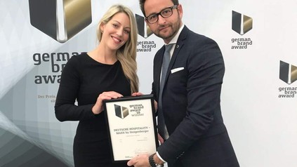 Zwei Geschäftsleute nehmen den German Brand Award entgegen