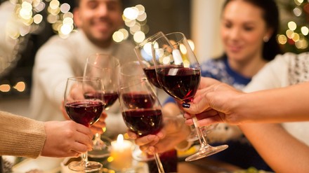 Eine Gruppe von Gästen stoßt mit Weingläsern an