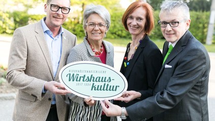 Harald Pollak, Petra Bohuslav, Birgit Wagner und August Teufl halten ein Schild mit der Aufschrift Niederösterreichische Wirtshauskultur seit 1994 hoch