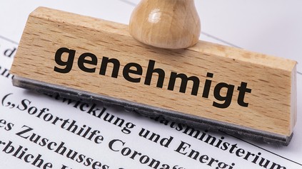 Antrag auf Soforthilfe Corona mit Holzstempel und Aufschrift genehmigt