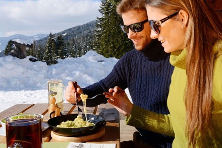 Mann und Frau essen draußen bei Schnee