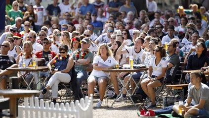 Menschen beim Public-Viewing der Fußball-Weltmeisterschaft in einem Biergarten