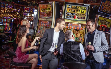 Casinobesucher vor Spielautomaten