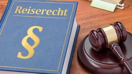 Ein Richterhammer und ein Buch mit dem Titel Reiserecht.