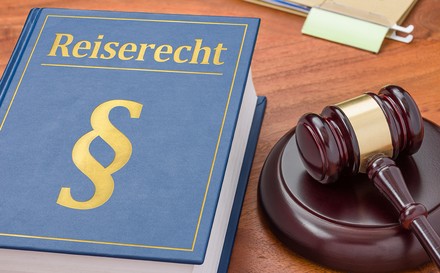 Ein Richterhammer und ein Buch mit dem Titel Reiserecht.