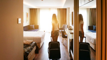 Eine Dame betritt ein Hotelzimmer