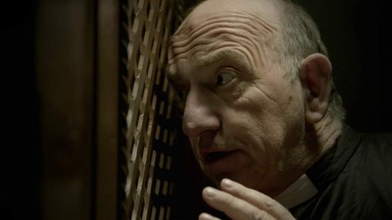 Pastor sitzt im Beichtraum