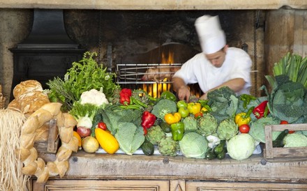 Ein Koch bei der Arbeit hinter einer Vielzahl frischen Gemüses