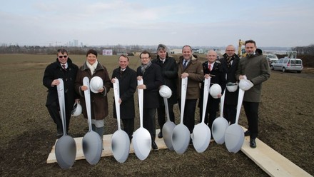 Neun Personen halten riesige Löffel