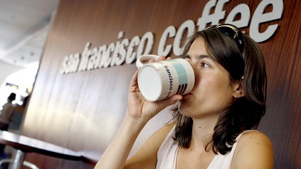 Frau trinkt Kaffee in einem Coffee Shop der San Francisco Coffee Company