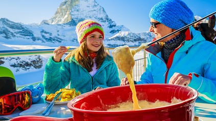 Skifahrer beim Fondue-Essen