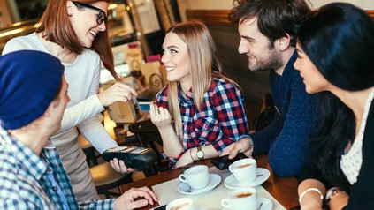 Kellnerin nimmt EC Karte von Frau an