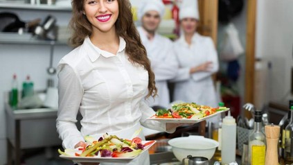 Frau hält zwei Teller mit Essen in der Hand