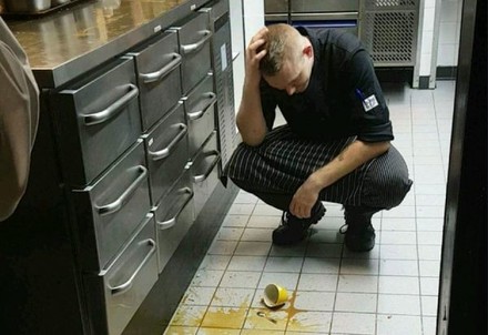 Küchenpersonal lässt Kaffeetasse in Küche fallen