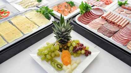 Ein Buffett mit Käse, Wurst, Lachs, Früchten und Gemüse