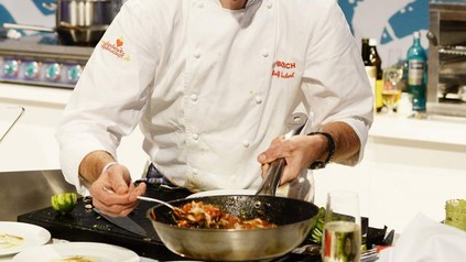 Ralf Zacherl lächelt und kocht Essen in Pfanne