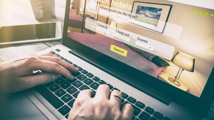 Mann am Laptop Buchung Hotel