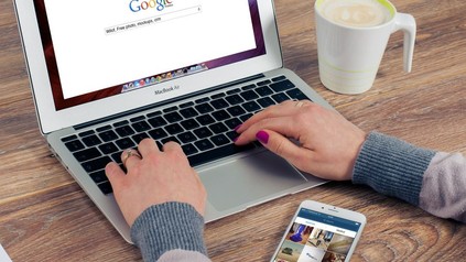 Frau sucht auf Laptop in Google