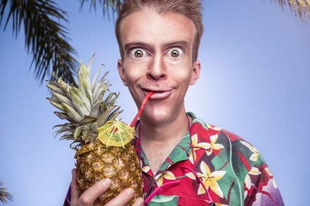 Frau in Hawaii-Hemd trinkt aus Ananas