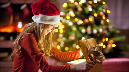 Frau packt Weihnachtsgeschenk aus