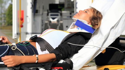 Patientin auf Trage vor Rettungswagen