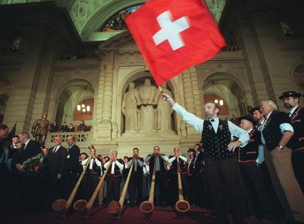 Mann hält stolz Schweizer Flagge hoch