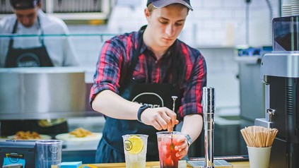 Eine Servicekraft bereitet Getränke zu