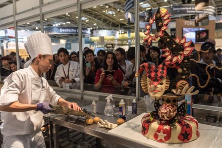 Ein japanischer Bäcker bereitet vor Publikum in der Schaubackstube auf der iba einen Kuchen zu