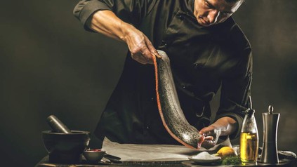 Ein Koch beim Zubereiten eines Fisches